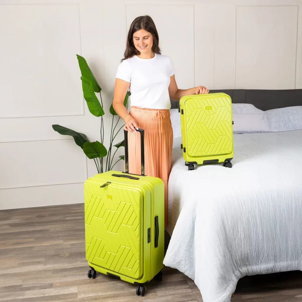 A woman holding a yellow suitcase next to a bed with a plant in the background.