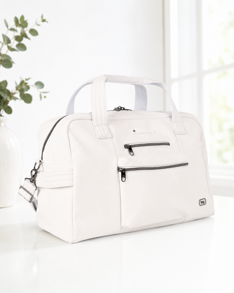 A stylish white duffel bag with black zipper details displayed on a table near a vase.